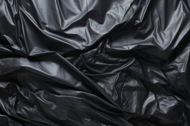 Siyah selofan çöp torbası dokusunun işlenmiş kolajı. Pankart, arkaplan veya 3B haritalama için doku