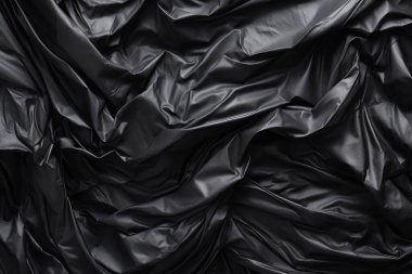 Siyah selofan çöp torbası dokusunun işlenmiş kolajı. Pankart, arkaplan veya 3B haritalama için doku