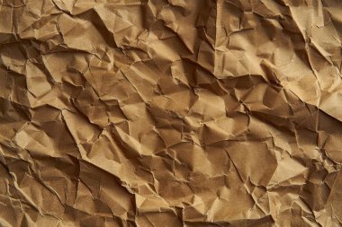 Buruşuk kahverengi kağıdın fotoğrafı. Kapatın. Arkaplan veya haritalama için arkaplan dokusu