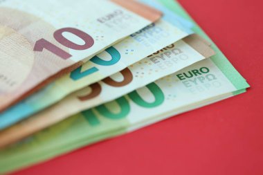 Büyük meblağda yüz, yirmi, on ve elli euro. Kırmızı arka planda. Yakın plan.