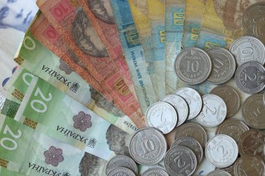 Ukraine money coins lying on mixed hryvnia banknotes, background. finance concept