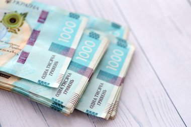 Beyaz ahşap masa üzerinde modern tasarımı olan büyük miktarda Ukrayna yapımı 100 Hryvnia para faturası. Finansal konsept, iş ücretleri