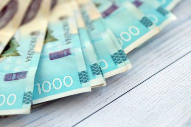 Beyaz ahşap masa üzerinde modern tasarımı olan büyük miktarda Ukrayna yapımı 100 Hryvnia para faturası. Finansal konsept, iş ücretleri