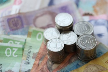 Birkaç yığın Ukrayna parası eski Hryvnia banknotlarının üzerinde yatıyor.