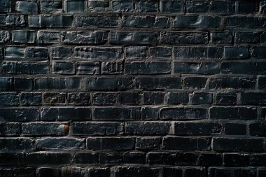 Eski tuğla duvarın resmi siyah renge boyanmış. Yakın plan. Arkaplan veya haritalama için arkaplan dokusu