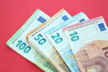 Büyük meblağda yüz, yirmi, on ve elli euro. Kırmızı arka planda. Yakın plan.