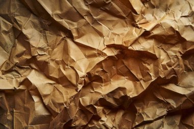 Buruşuk kahverengi kağıdın fotoğrafı. Kapatın. Arkaplan veya haritalama için arkaplan dokusu