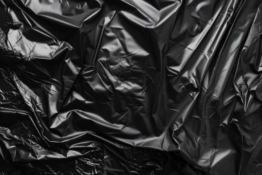 Buruşmuş siyah politen plastik ambalaj kağıdının fotoğrafı. Arkaplan veya haritalama için arkaplan dokusu