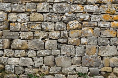 Eski gri ve kahverengi taş duvarın fotoğrafı. Arkaplan veya haritalama için arkaplan dokusu
