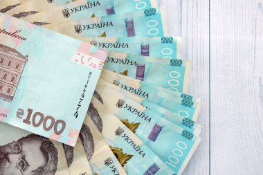 Beyaz ahşap masa üzerinde modern tasarımı olan büyük miktarda Ukrayna yapımı 100 Hryvnia para faturası. Finansal konsept, iş ücretleri