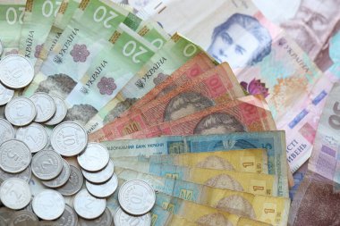 Ukraine money coins lying on mixed hryvnia banknotes, background. finance concept