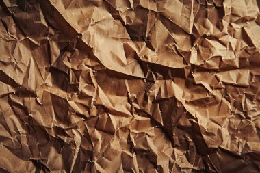 Buruşuk kahverengi kağıdın fotoğrafı. Kapatın. Arkaplan veya haritalama için arkaplan dokusu