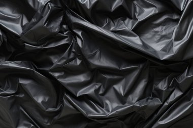 Siyah selofan çöp torbası dokusunun işlenmiş kolajı. Pankart, arkaplan veya 3B haritalama için doku