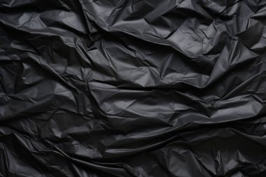 Siyah selofan çöp torbası dokusunun işlenmiş kolajı. Pankart, arkaplan veya 3B haritalama için doku