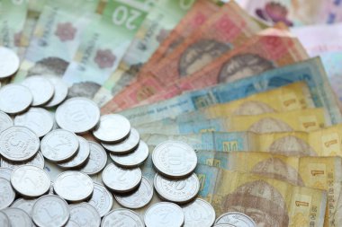 Ukraine money coins lying on mixed hryvnia banknotes, background. finance concept