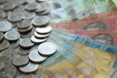 Ukraine money coins lying on mixed hryvnia banknotes, background. finance concept