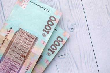 Beyaz ahşap masa üzerinde modern tasarımı olan büyük miktarda Ukrayna yapımı 100 Hryvnia para faturası. Finansal konsept, iş ücretleri