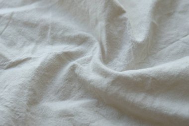 Arka plan olarak beyaz renkli gri tekstil peçetesi. Katlanmış dekoratif mutfak pamuğu havlusu kapat.