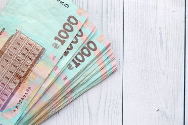 Beyaz ahşap masa üzerinde modern tasarımı olan büyük miktarda Ukrayna yapımı 100 Hryvnia para faturası. Finansal konsept, iş ücretleri