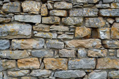 Eski gri ve kahverengi taş duvarın fotoğrafı. Arkaplan veya haritalama için arkaplan dokusu