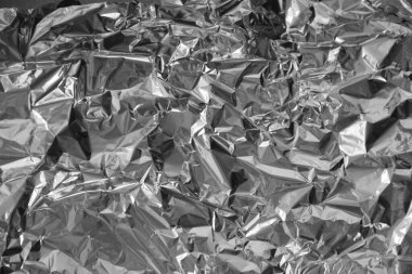 Parlak metalden işlenmiş gümüş folyo buruşmuş ambalaj malzemesi dokusu arka planı.