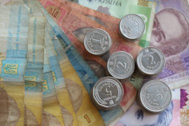 Birkaç yığın Ukrayna parası eski Hryvnia banknotlarının üzerinde yatıyor.