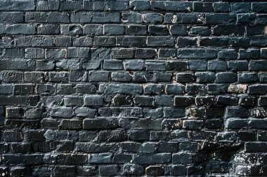 Eski tuğla duvarın resmi siyah renge boyanmış. Yakın plan. Arkaplan veya haritalama için arkaplan dokusu