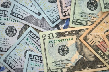 Büyük miktarlarda farklı banknotlar kapanıyor. Yüz elli yirmi on ve beş dolarlık banknotlar istiflendi.