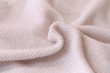Örülmüş pastel pembe süveter dokusu, yakın çekim bej pembe örgü kumaş dokusu.