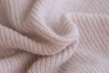 Örülmüş pastel pembe süveter dokusu, yakın çekim bej pembe örgü kumaş dokusu.