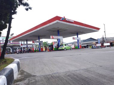 Bandung, Endonezya - 07 Mayıs 2025: Pertamina benzinliği şehir bölgesinde yakıt ikmali yapan arabalar ve motorsikletler