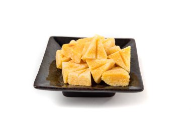 Saffron spiced sugar cubes in a pile on a black tray side view