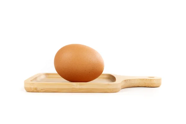 stock image Farm fresh brown egg in a tiny cutting board isolated over white