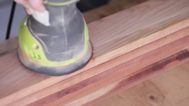 Yörünge zımparası sedir ağacını düzleştirmek için birden fazla geçiş yapıyor.