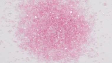 Parlak pembe şeker kristal serpintiler saat yönünde dönüyor.