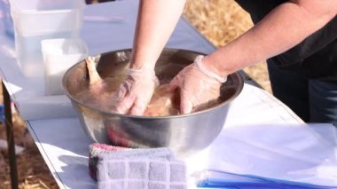 Gümüş bir kazanda su ve sirke ile durulanan doğranmış tavuk leşi.