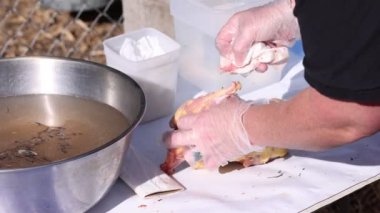 Dışarıdaki masada doğranmış bir tavuk leşini temizlemek..