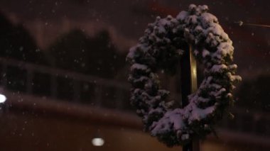 Kopya alanı için güneş doğmadan önce düşen kardaki bir direkte Evergreen çelengi.
