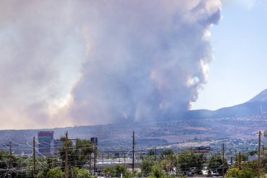 Davis 'ten çıkan duman sütunları Reno' nun güneyinde Atlantis kumarhanesinin manzarası ve ön planda elektrik hatları ile yangın çıkarıyor.