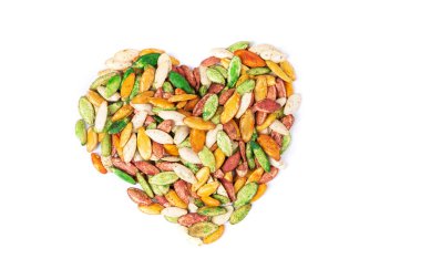 Kızarmış tuzlu bezelyeler, beyaz üzerine izole edilmiş kalp şeklinde.