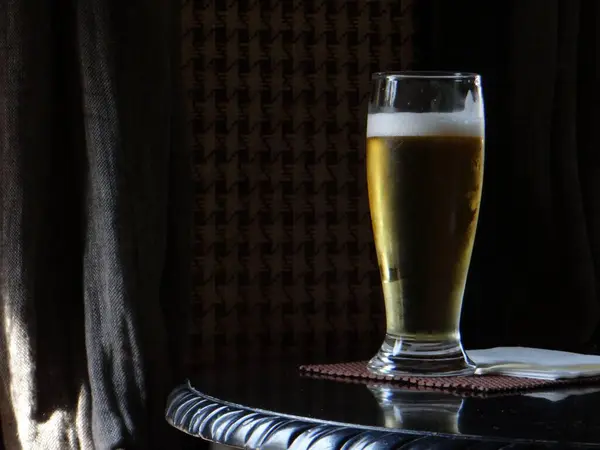 Masanın üzerinde soğuk, terli bir bardak bira.