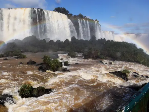 Iguazu Nehri ve arka planda güzel bir gökkuşağı ile şelale.