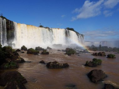 Güçlü şelaleler Iguazu Nehri 'ne dökülüyor. Sis ve canlı bir gökkuşağı yaratıyor..