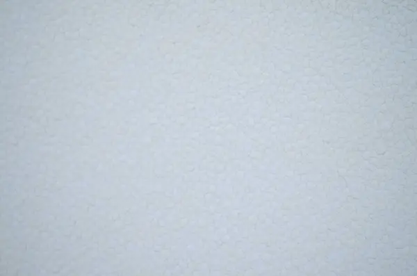 Beyaz granüle bir dokuya yakın çekim, muhtemelen plastik veya yalıtım malzemesi..