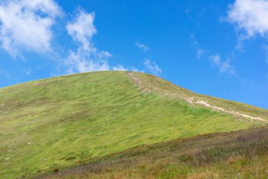 Hoverla Dağı. Ukrayna Karpatlarının zirvesindeki Hoverla Dağı gökyüzü ve bulutların arka planında asılı. Karpat Dağları 'nda yaz manzarası. Ukrayna. İnsanlar Hoverla Dağı 'na tırmanıyor