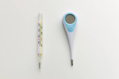 Ev için termometre. Beyaz arka planda iki farklı termometre var. Merkür, kızılötesi termometre.