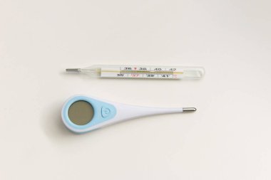 Ev için termometre. Beyaz arka planda iki farklı termometre var. Merkür, kızılötesi termometre.