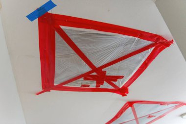 Hasarlı tavanın tamiri. Dairelerin tavanında bir delik. Açı el elektrikli elektrikli aletler ile hasar görmüş alçı taşı alçı tabaka kesimi. 