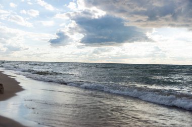 Michigan Gölü kıyılarında yumuşak dalgalar ve dramatik bulutlar var. Huzurlu doğal deniz manzarası, doğa, seyahat ve rahatlama temaları için birebirdir. Bir yaz öğleden sonra çekilmiş..