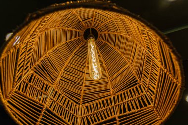 Hasır bir ahşap abajurlu bir lamba, güzel bir alt manzara. Sıcak ev atmosferi, sıcak ışık, çevre dostu malzemeler..